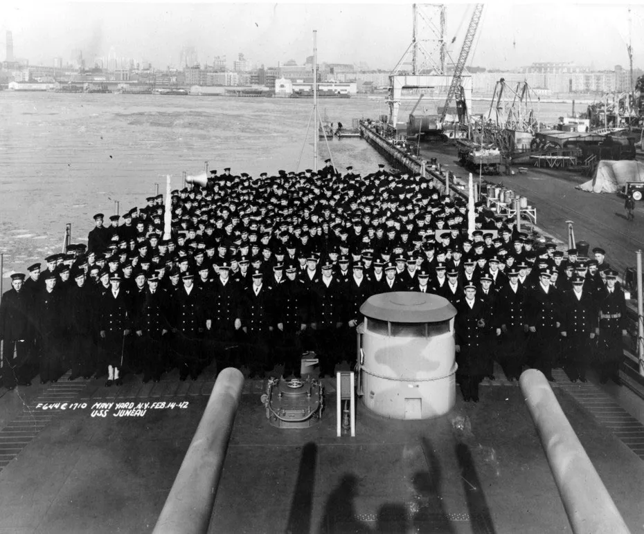 Hundreds of USS Juneau crewmen assembled on the fantail at the Brooklyn Navy Yard on 14 February 1942, main gun barrels in the foreground