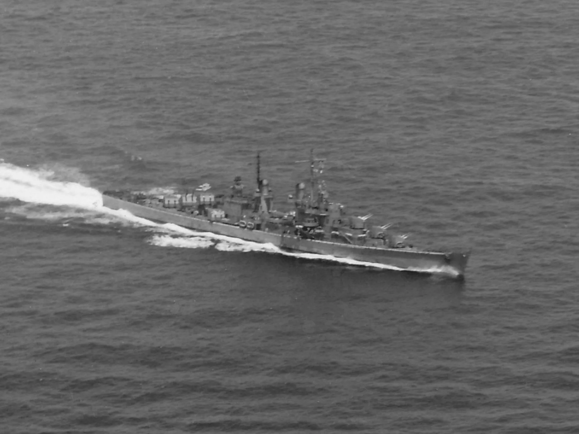 Aerial photograph of USS Juneau steaming at high speed in the Pacific on 26 October 1942, leaving a long white wake
