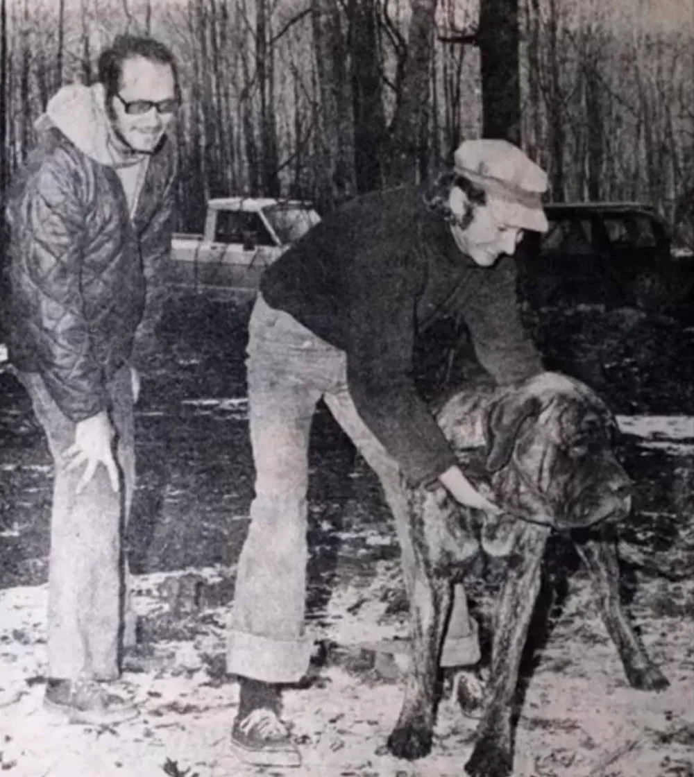Joseph Odom on the left and Charles Scudder on the right with a mastiff outside their home.